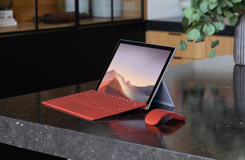 桌子上的 Surface Pro 7 搭配键盘盖和 Arc 鼠标